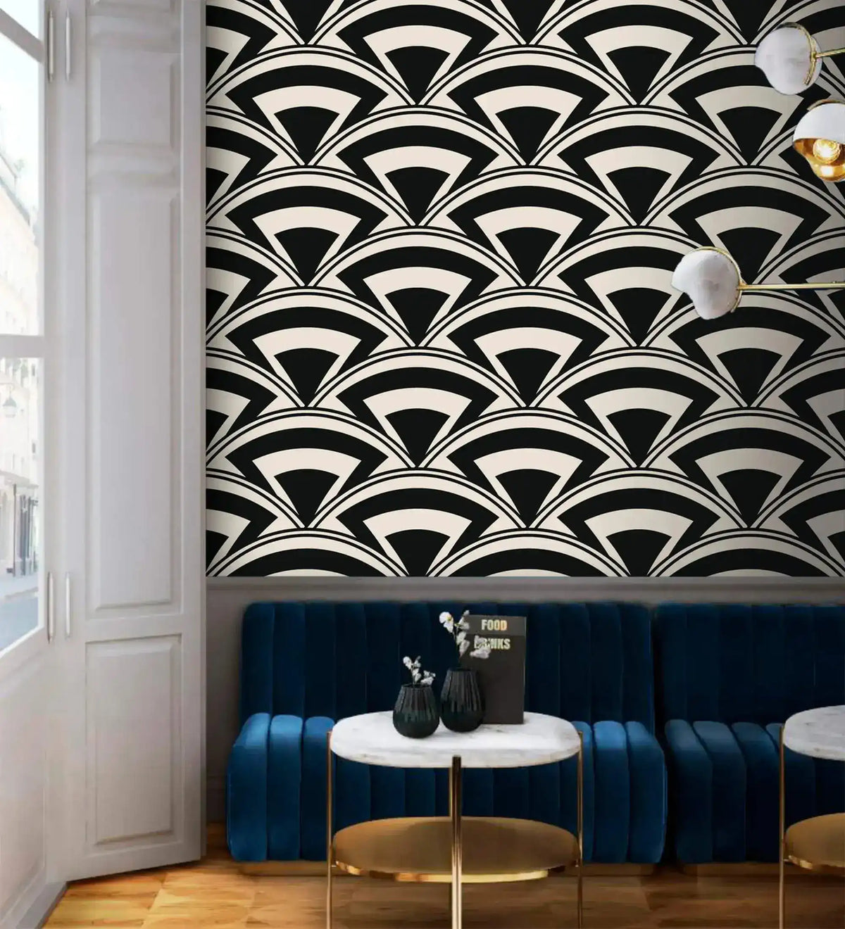 Monochrome deco fan wallpaper above a blue velvet banquette with marble bistro tables in a lounge