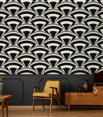 Monochrome deco fan wallpaper above dark wainscoting with mustard mid-century chair and wood credenza