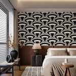 Monochrome deco fan wallpaper in black and cream above wood paneling in a calm neutral bedroom