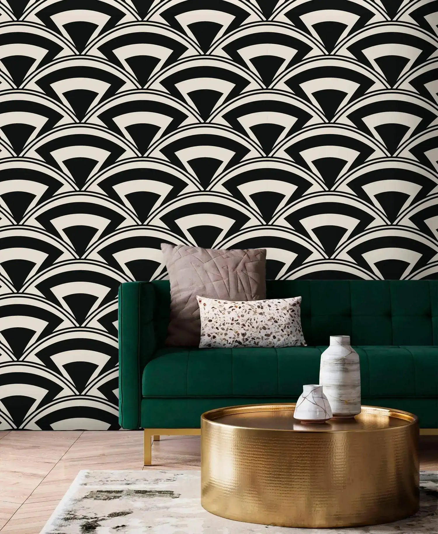 Monochrome deco fan wallpaper in black and cream behind an emerald sofa with brass drum table