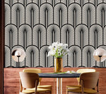 Monochrome Deco fan wallpaper over wood panelling in a dining nook with round table