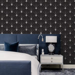 Black and white Art Deco arch wallpaper behind navy upholstered headboard, with agate-base lamp on silver bedside table