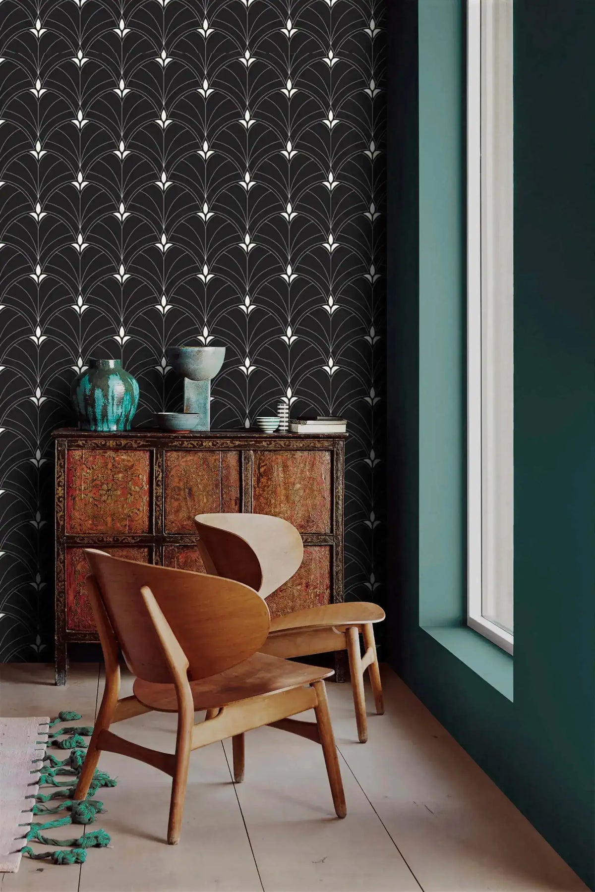 Black Art Deco arch wallpaper in a minimalist corner with oak lounge chair, vintage chest and teal ceramic vases