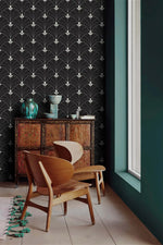Black Art Deco arch wallpaper in a minimalist corner with oak lounge chair, vintage chest and teal ceramic vases