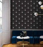 Monochrome Majesty black Art Deco arch wallpaper in a lounge with navy velvet banquette seating and gold globe wall sconce
