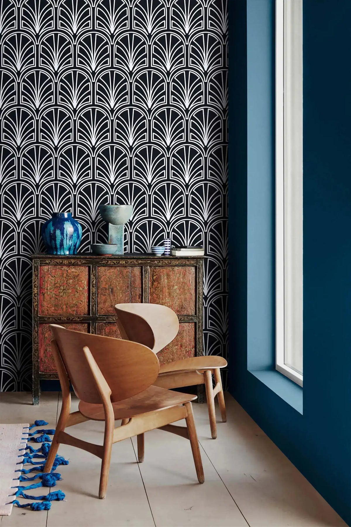 Monochrome vintage geometric wallpaper by a window, white deco palmettes on navy above carved cabinet