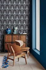 Monochrome vintage geometric wallpaper by a window, white deco palmettes on navy above carved cabinet