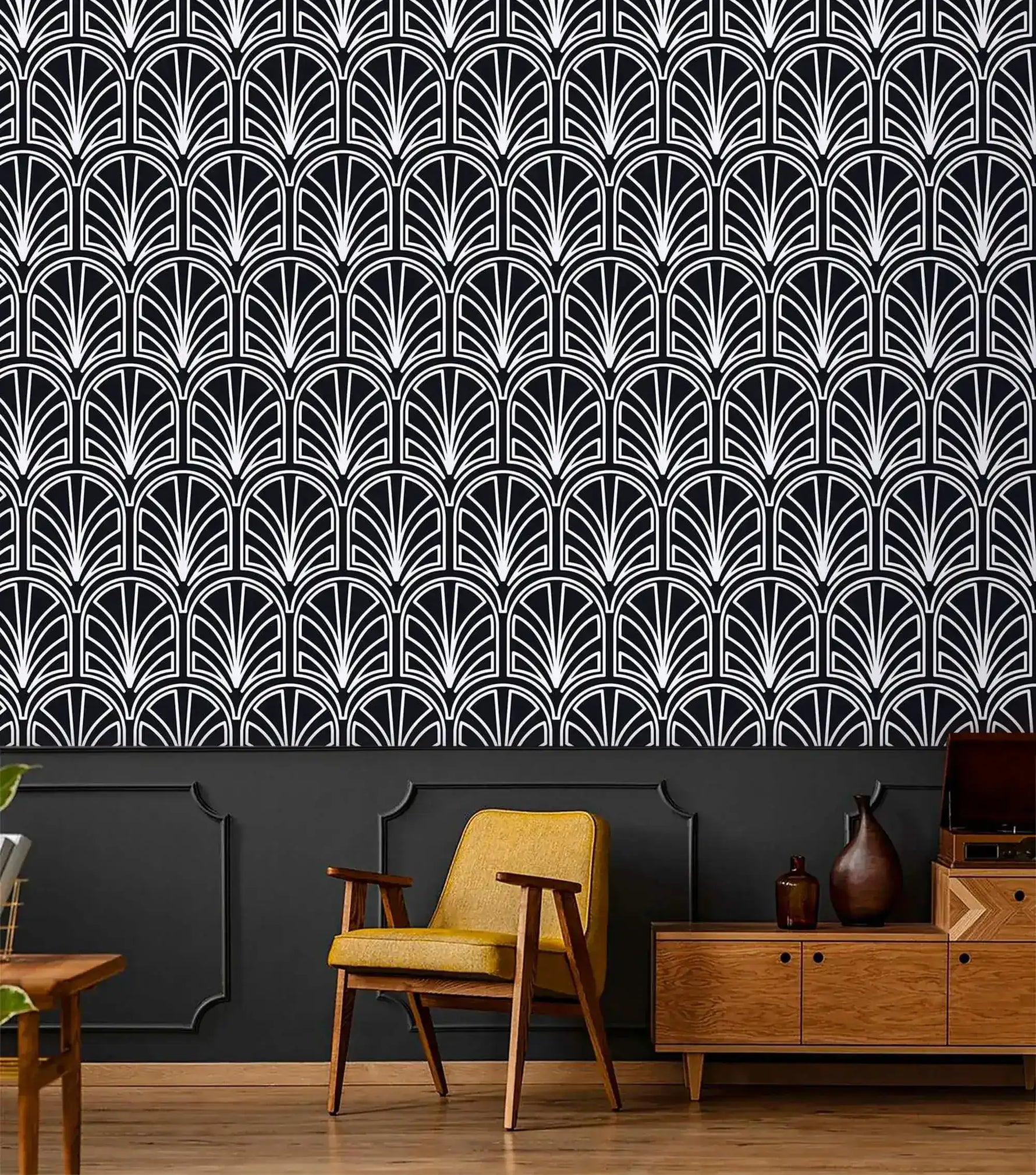 Monochrome vintage geometric wallpaper, white deco palmettes on black above paneling with yellow chair