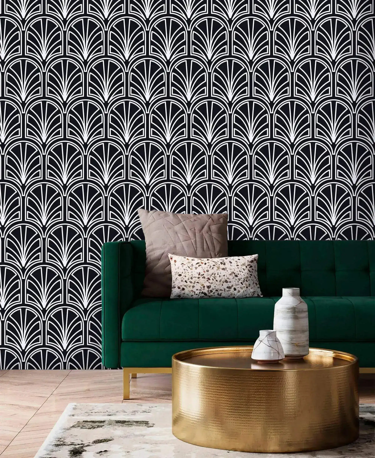 Monochrome vintage geometric wallpaper, white deco palmettes on black behind an emerald velvet sofa