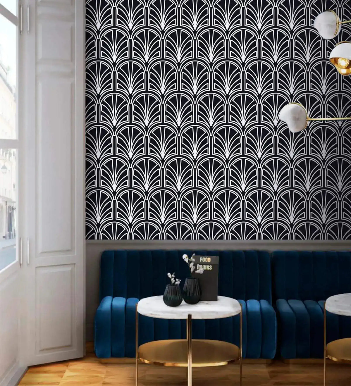 Monochrome vintage geometric wallpaper, white deco palmettes on navy above a blue velvet banquette