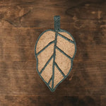 A unique Monstera leaf-shaped area rug crafted from natural jute, ideal for adding a touch of nature to living rooms or offices. This stylish jute rug features a detailed leaf design, perfect for those seeking eco-friendly living room area rugs or rugs for the office.