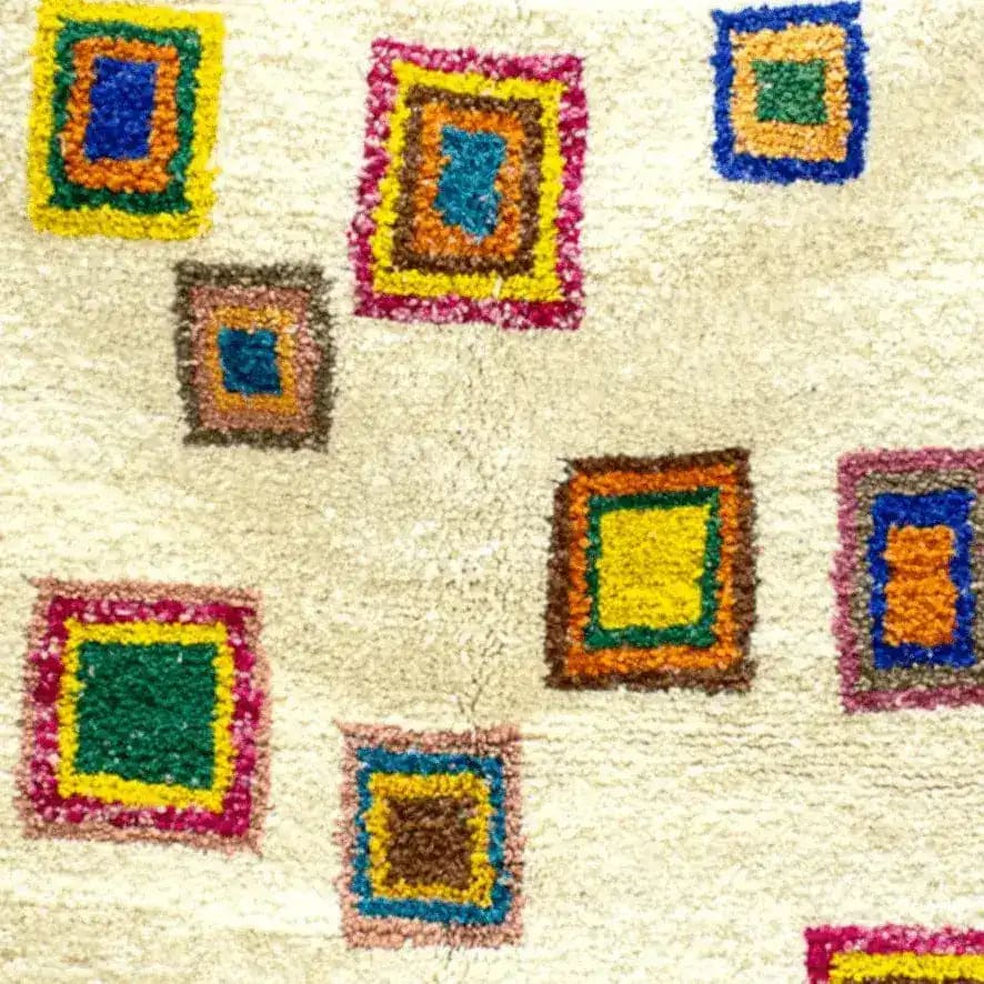 Close-up view of a Moroccan Bohemian Azila Area Rug featuring colorful geometric patterns on a soft, wool texture. Perfect wool rug for adding a vintage touch to living room decor.