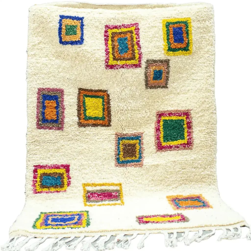 This Moroccan Bohemian Azila Area Rug with Tassels showcases a vibrant design featuring colorful geometric patterns on a cream wool base. Ideal for adding a vintage touch to living room decor, this wool rug combines traditional craftsmanship with a modern flair, making it a standout piece among area rugs for living rooms.