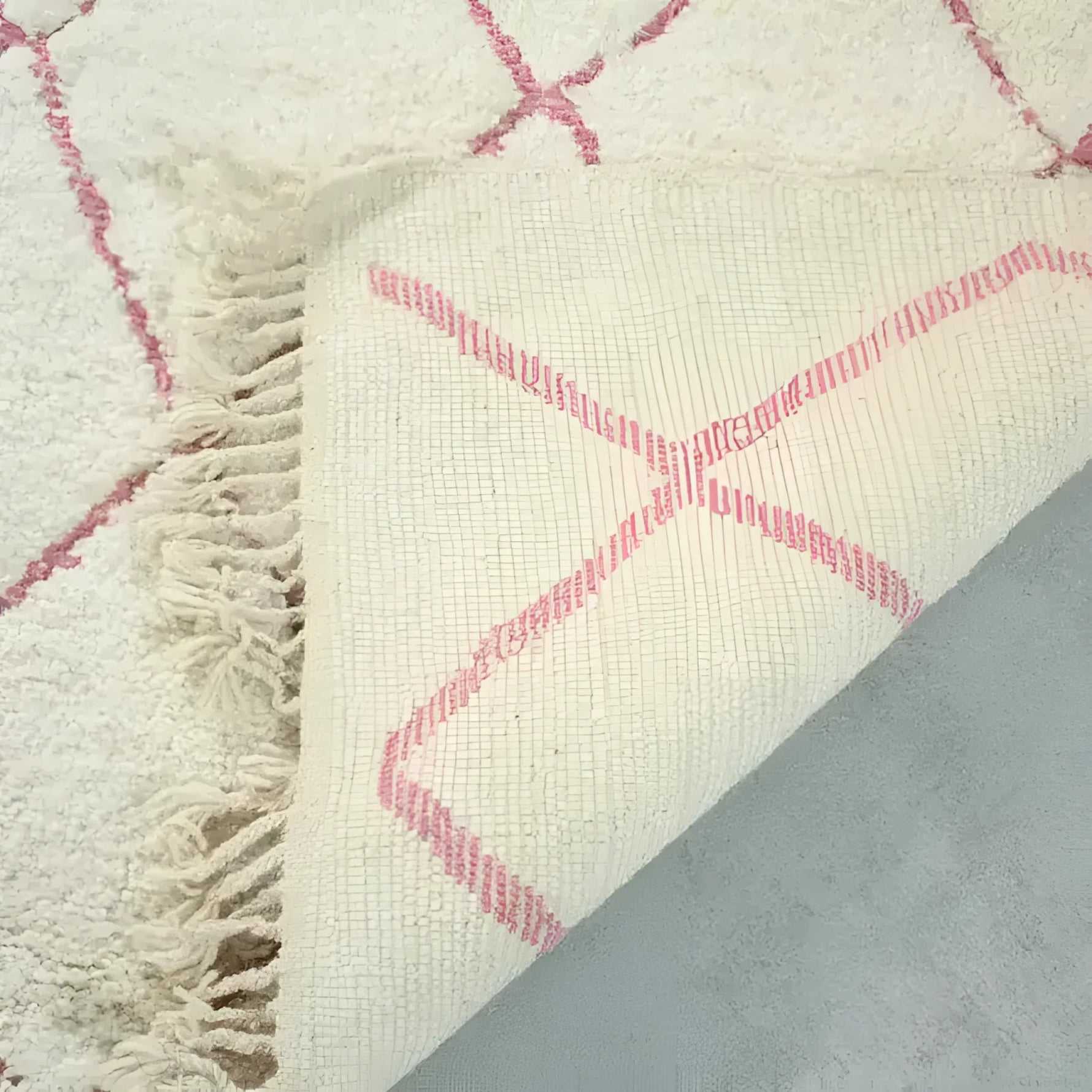 Close-up of a Moroccan Pink Beni Ouarain Classic Area Rug showcasing its intricate wool texture and vintage-inspired pink diamond pattern, perfect for large living rooms.
