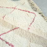 Close-up of a Moroccan Pink Beni Ouarain Classic Area Rug showcasing its plush wool texture and subtle pink geometric patterns. This vintage rug is perfect for large living room spaces, adding a touch of elegance and warmth.