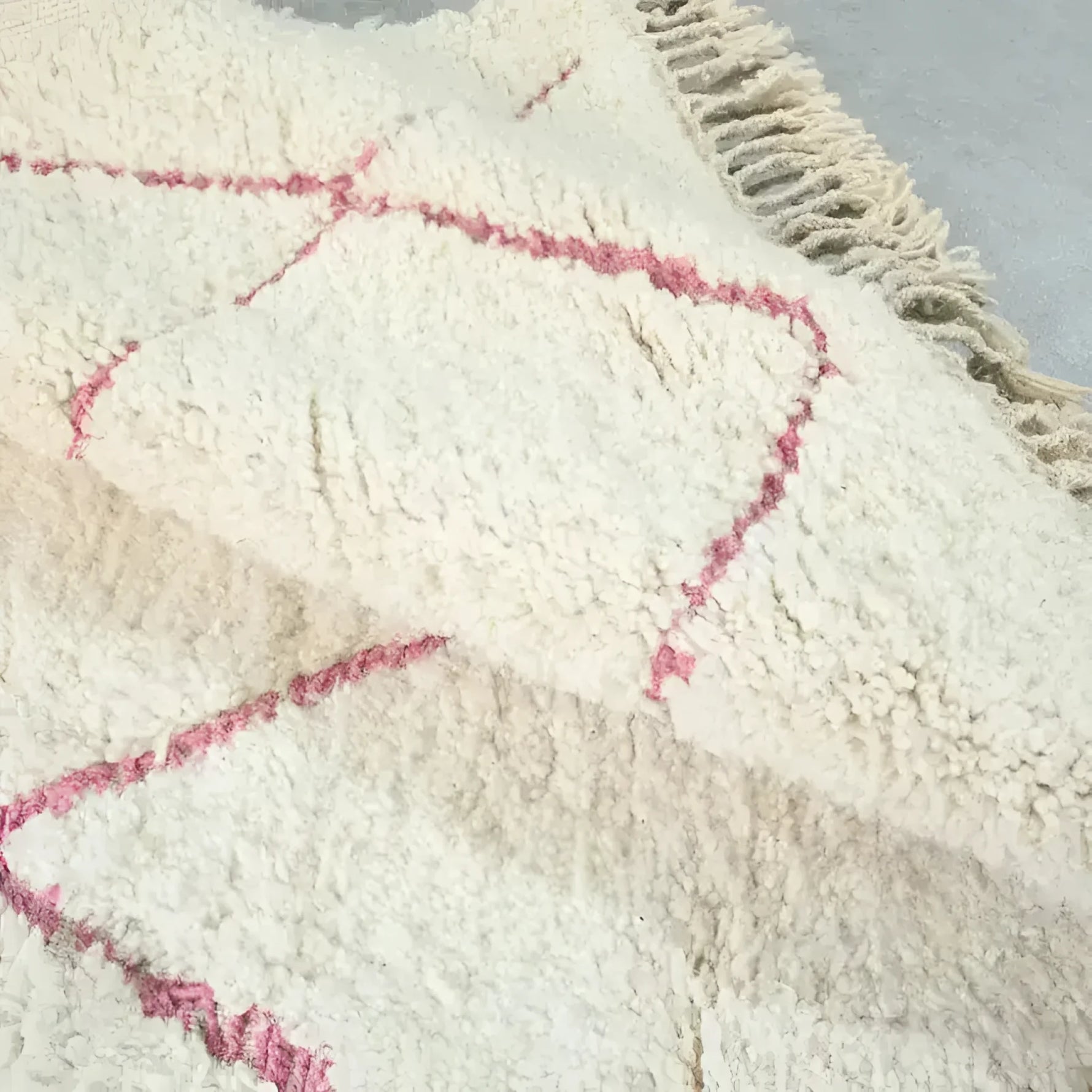 Close-up of a Moroccan Pink Beni Ouarain Classic Area Rug showcasing its plush wool texture and subtle pink geometric patterns. This vintage rug is perfect for large living room spaces, adding a touch of elegance and warmth.