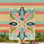 Person holding a colorful abstract patterned rug against a striped wall.
