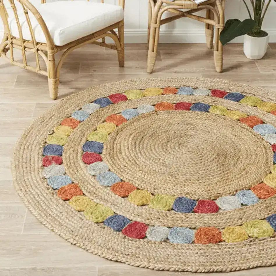 Vibrant Motley Braided Round Jute Rug displayed in a cozy dining room setting. The large area rug, perfect for under a dining table, features colorful woven patterns ideal for boho decor. This versatile jute rug adds texture and warmth to both living room and dining room spaces.