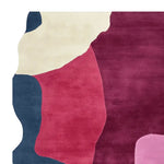 A vibrant area rug featuring a contemporary abstract design with bold colors including deep blue, rich red, cream, and pink. This wool rug is perfect for adding a touch of modern elegance to large living rooms.