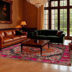 A luxurious living room featuring a multicolored floral wool hand-knotted area rug with vibrant pink and orange hues. This square area rug is elegantly placed under a wooden coffee table, surrounded by a leather sofa and a velvet couch, creating a perfect setting for a dining room or living room. The intricate floral patterns add a touch of Persian rug charm, making it an ideal choice for dining room carpets and enhancing the cozy atmosphere.