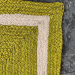 Close-up of a vibrant mustard and gray braided jute area rug, showcasing intricate weaving and texture. Perfect for adding warmth to a dining room or as an 8x10 living room rug, this piece enhances any space with its natural charm.