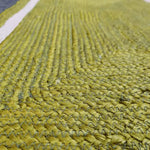 Close-up view of a mustard and gray braided jute rug, showcasing the intricate weaving pattern, perfect for adding a natural touch to your dining room or living room. Ideal as an 8x10 area rug for living room spaces.
