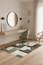 Modern interior with a round mirror, desk, and chairs on a patterned green rug.
