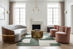 Modern living room with a green rug, curved sofa, round coffee table, and pink chairs.