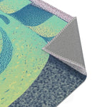 Flat corner of lime-green teal body with blue-stippled shoulder and grey anti-slip backing with pink overlock, Mystic Guardian Accent Rug