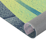 Corner fold showing yellow-green teal speckled print face and grey anti-slip backed overlock stitching, Mystic Guardian Accent Rug