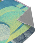 Corner fold revealing green-teal abstract figure chest and white beard detail with grey anti-slip backing, Mystic Guardian Accent Rug
