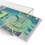 Angled overhead view of clear acrylic Mystic Guardian Serving Tray showing teal and yellow abstract geometric art through sides