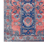 A close-up view of the Mystic Heritage Hand Tufted Area Rug, showcasing its intricate vintage design. The wool rug features a vibrant mix of coral, navy, and grey hues with floral and geometric patterns, perfect for adding a classic touch to your living room.