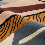 Close-up of a textured rug with abstract patterns in earthy tones.