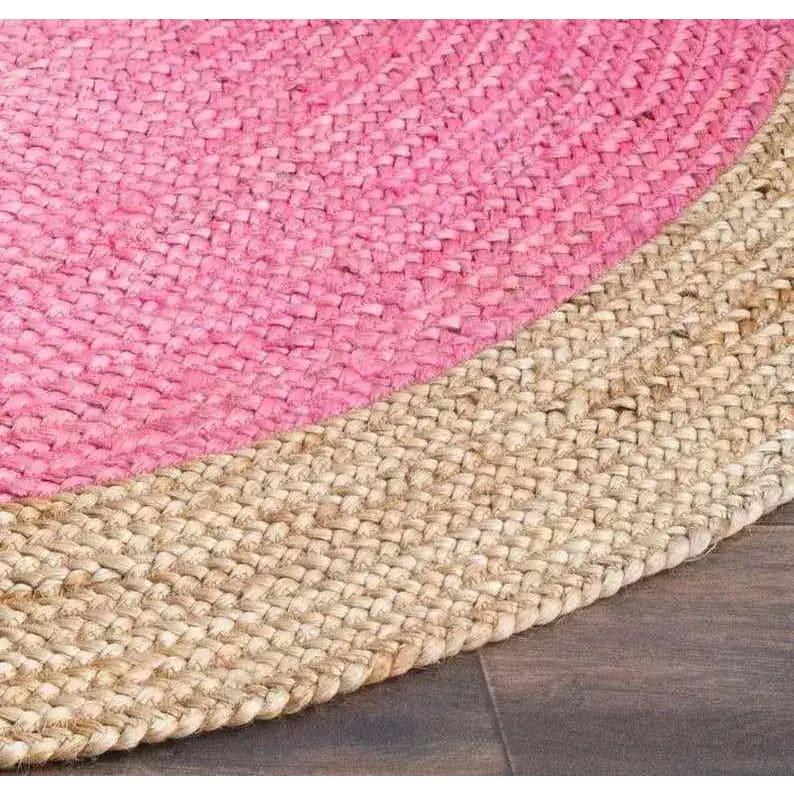 A vibrant and natural bordered bright pink round jute area rug, perfect for adding a boho touch to your living room. The rug features a pink center with a natural jute border, showcasing a textured weave that's ideal for any space.