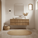 Bathroom with wooden vanity, mirror, and decorative elements.