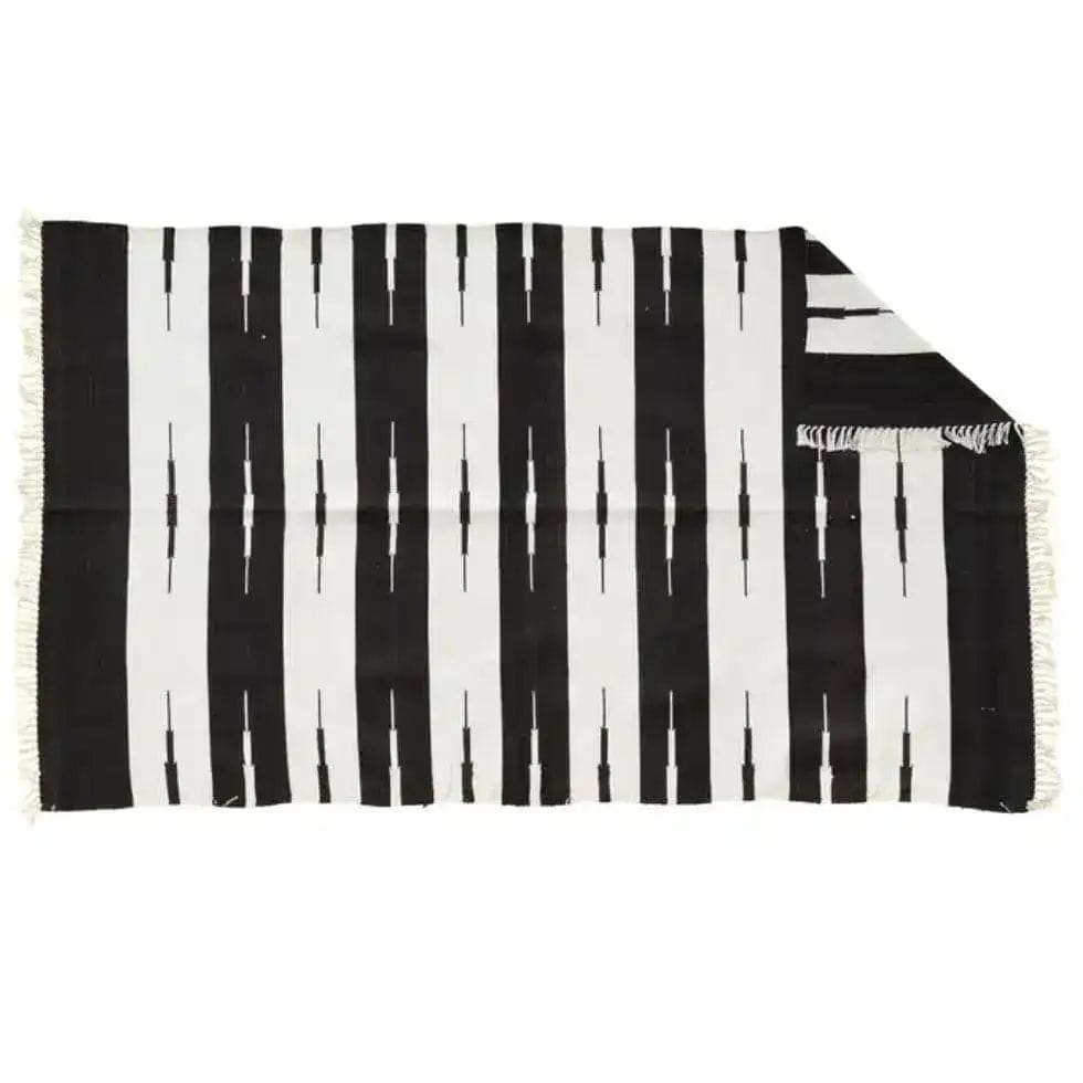 Stylish black and white striped area rug made from natural vegetable-dyed cotton, perfect for living rooms. This boho rug is reversible and ideal for adding a chic touch to your space. Suitable for living room rugs 8x10, this cotton rug features a classic pattern with fringe detailing for a cozy, bohemian vibe.