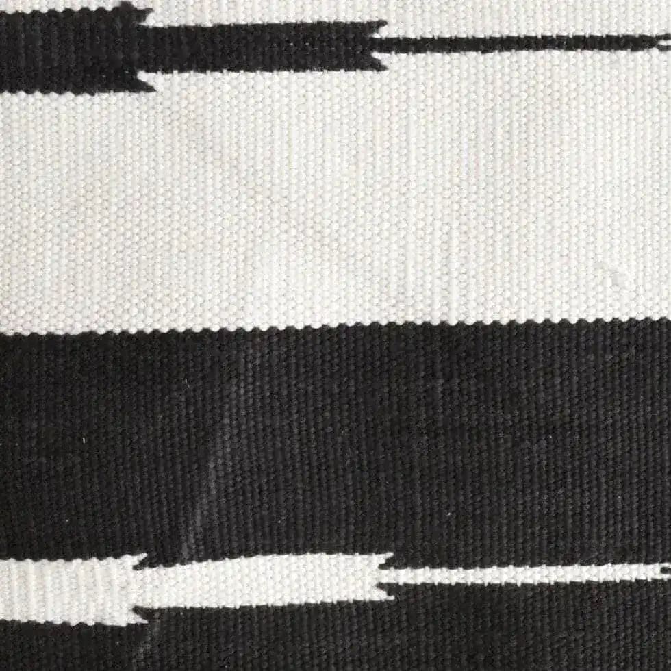 Close-up view of a Natural Vegetable Dyed Indian Dhurrie Reversible Cotton Area Rug in black and white. This boho rug, perfect for the living room, features a striking pattern ideal for living room rugs 8x10, adding a touch of elegance to any space.