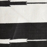 Close-up view of a Natural Vegetable Dyed Indian Dhurrie Reversible Cotton Area Rug in black and white. This boho rug, perfect for the living room, features a striking pattern ideal for living room rugs 8x10, adding a touch of elegance to any space.