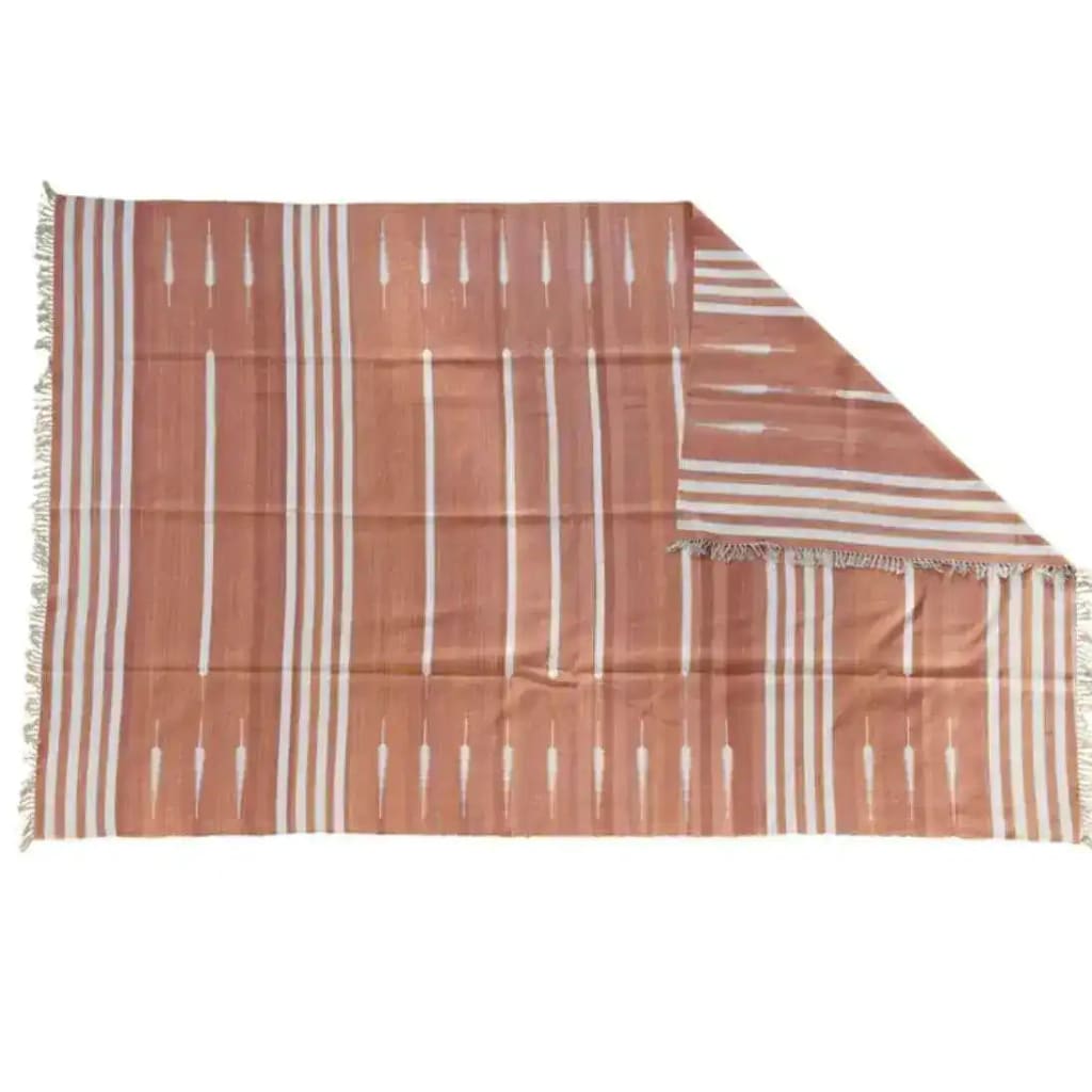 A beautifully crafted Natural Vegetable Dyed Indian Dhurrie Reversible Cotton Rug in a warm clay color, ideal for living rooms. This area rug features a simple yet elegant linear pattern, perfect for adding a boho touch to your space. Suitable for those seeking an 8x10 living room area rug with the comfort of cotton.