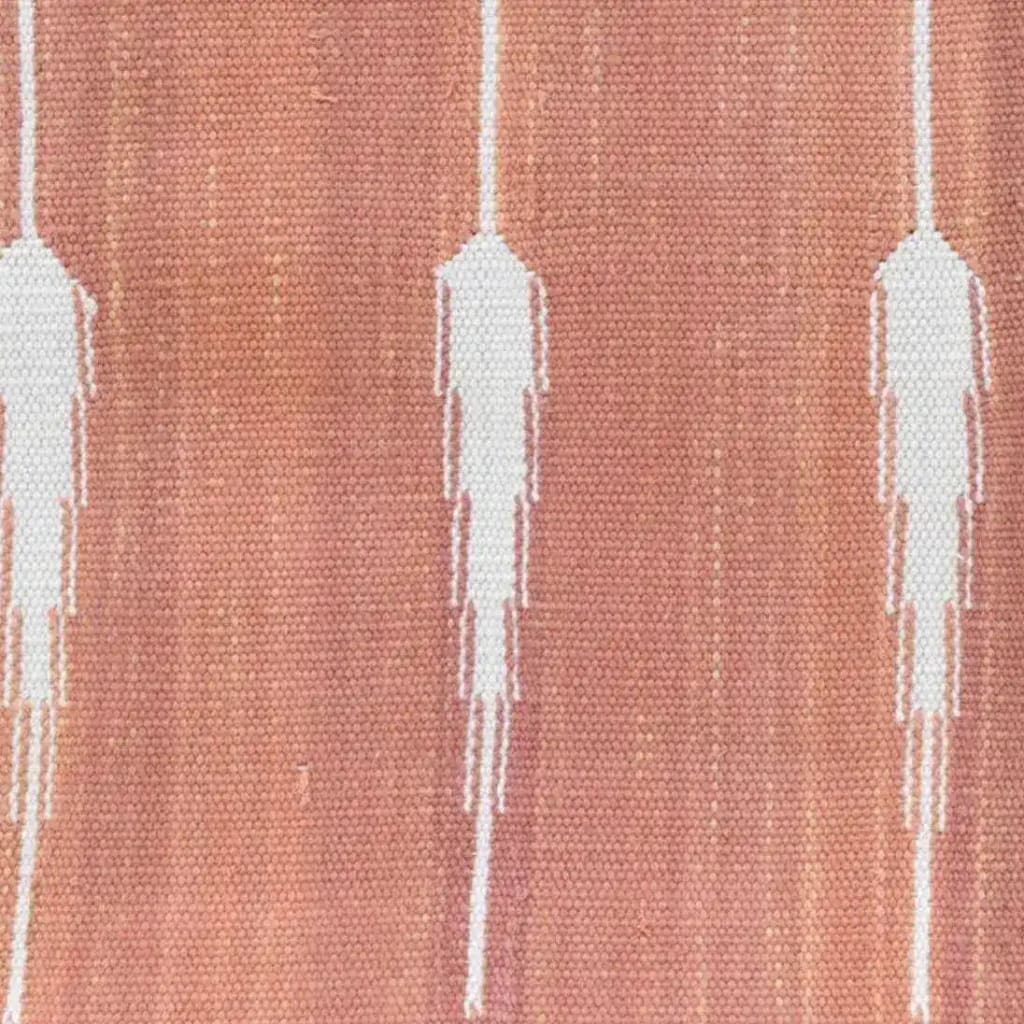 Close-up view of a Natural Vegetable Dyed Indian Dhurrie Reversible Cotton Rug in clay color, showcasing abstract white patterns. Perfect for living room area rugs, especially in an 8x10 size, this boho rug adds a touch of elegance and warmth to any living room space.