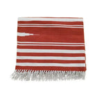 This image showcases a beautifully crafted Natural Vegetable Dyed Indian Dhurrie Reversible Cotton Area Rug in a striking red and white striped pattern. Perfect for adding a boho touch to living room area rugs or office rugs, this cotton rug features intricate fringe detailing, making it an ideal choice for both living room and office settings.