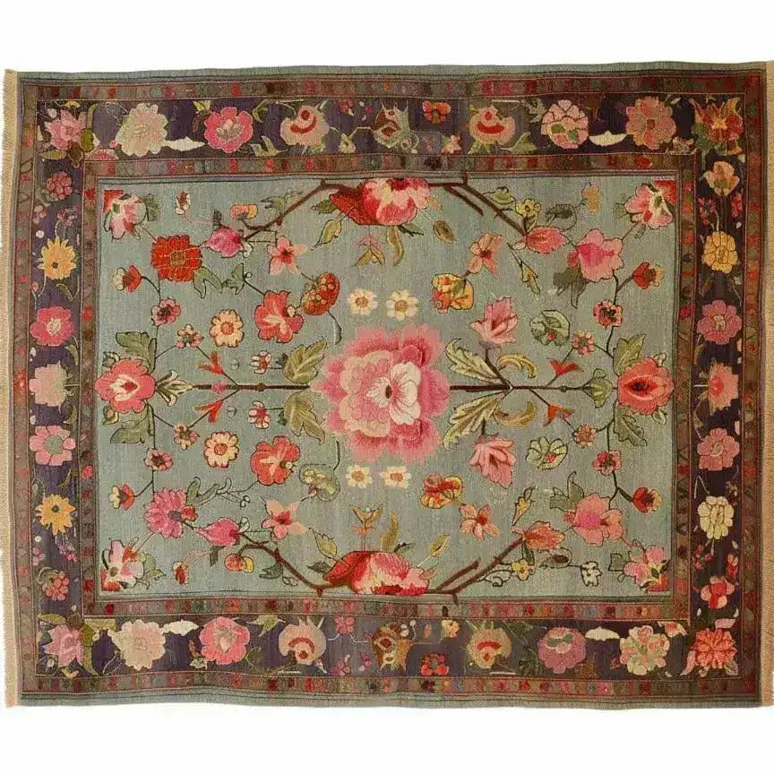 A stunning hand-knotted area rug featuring an intricate floral design. This living room area rug showcases vibrant pink and red flowers on a soft blue background, reminiscent of traditional Persian rugs. Perfect for adding elegance to any space, this floral rug is ideal for those seeking beautiful area rugs for the living room.
