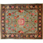 A stunning hand-knotted area rug featuring an intricate floral design. This living room area rug showcases vibrant pink and red flowers on a soft blue background, reminiscent of traditional Persian rugs. Perfect for adding elegance to any space, this floral rug is ideal for those seeking beautiful area rugs for the living room.