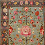 A beautifully detailed hand-knotted area rug featuring an elegant floral design with vibrant pink and red flowers on a soft blue background. This exquisite piece captures the essence of Persian rugs, perfect for enhancing the charm of living room area rugs. Its intricate patterns make it a standout choice for anyone seeking a floral rug to add sophistication to their home decor.
