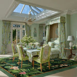 Elegant dining room featuring a square area rug with a vibrant floral design, perfect for adding a touch of nature to your space. The wool rug complements the sophisticated green decor, ideal for large living room or dining room carpets. This cozy setting, bathed in natural light, showcases how the Nature's Serenade Hand Tufted Wool Rug enhances any living room.