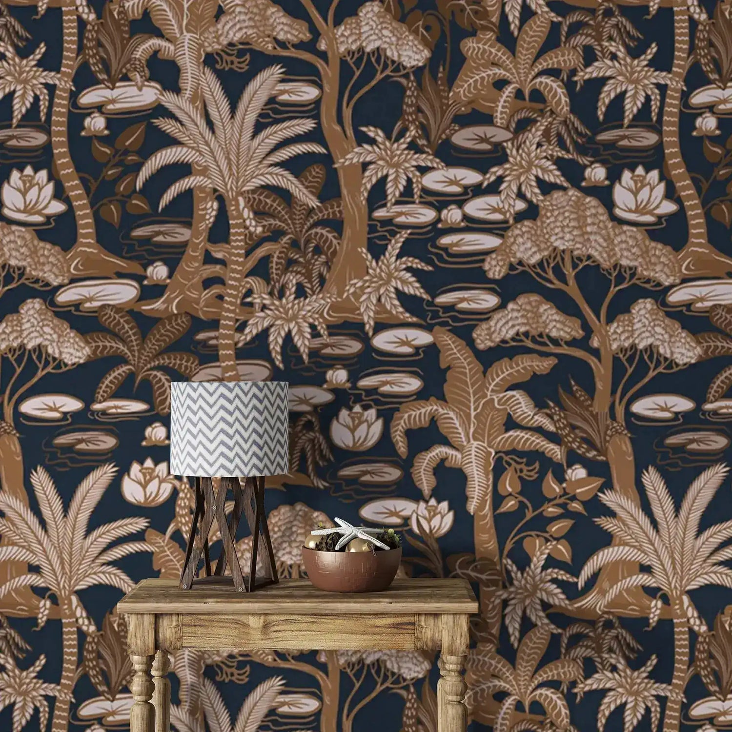 Navy palm tree wallpaper in copper tones behind a rustic console table with lamp and bowl