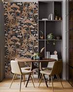 Navy palm tree wallpaper in copper tones in a dining nook with round table, chairs and grey shelving