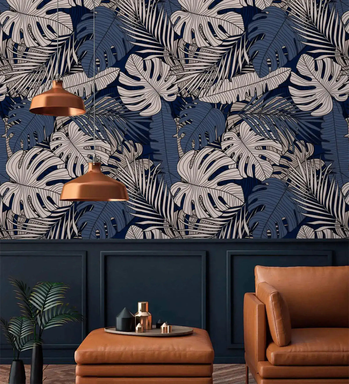 Navy tropical midnight leaves wallpaper above paneled wainscoting, styled with leather armchair and copper pendants