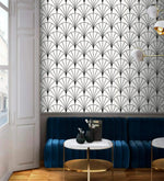 Navy velvet banquette and marble tables against monochrome round line deco fan wallpaper